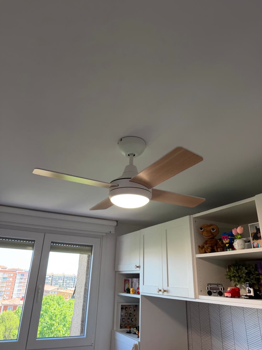 Ventilador de techo con aspas de madera y luz instalado en una habitación