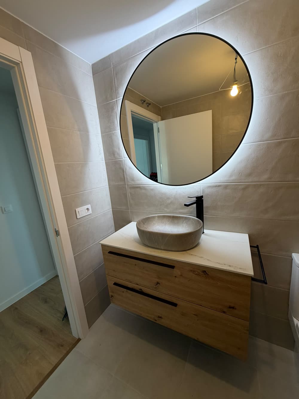 Mueble de lavabo de madera con espejo redondo retroiluminado